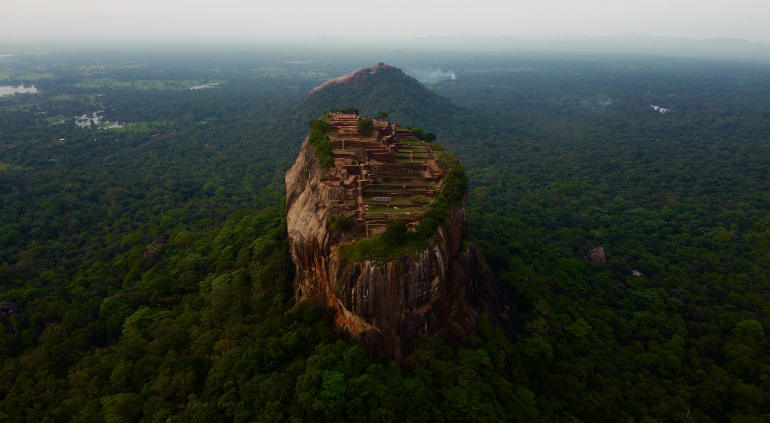 Sigiriya rock rising above green forest in Sri Lanka